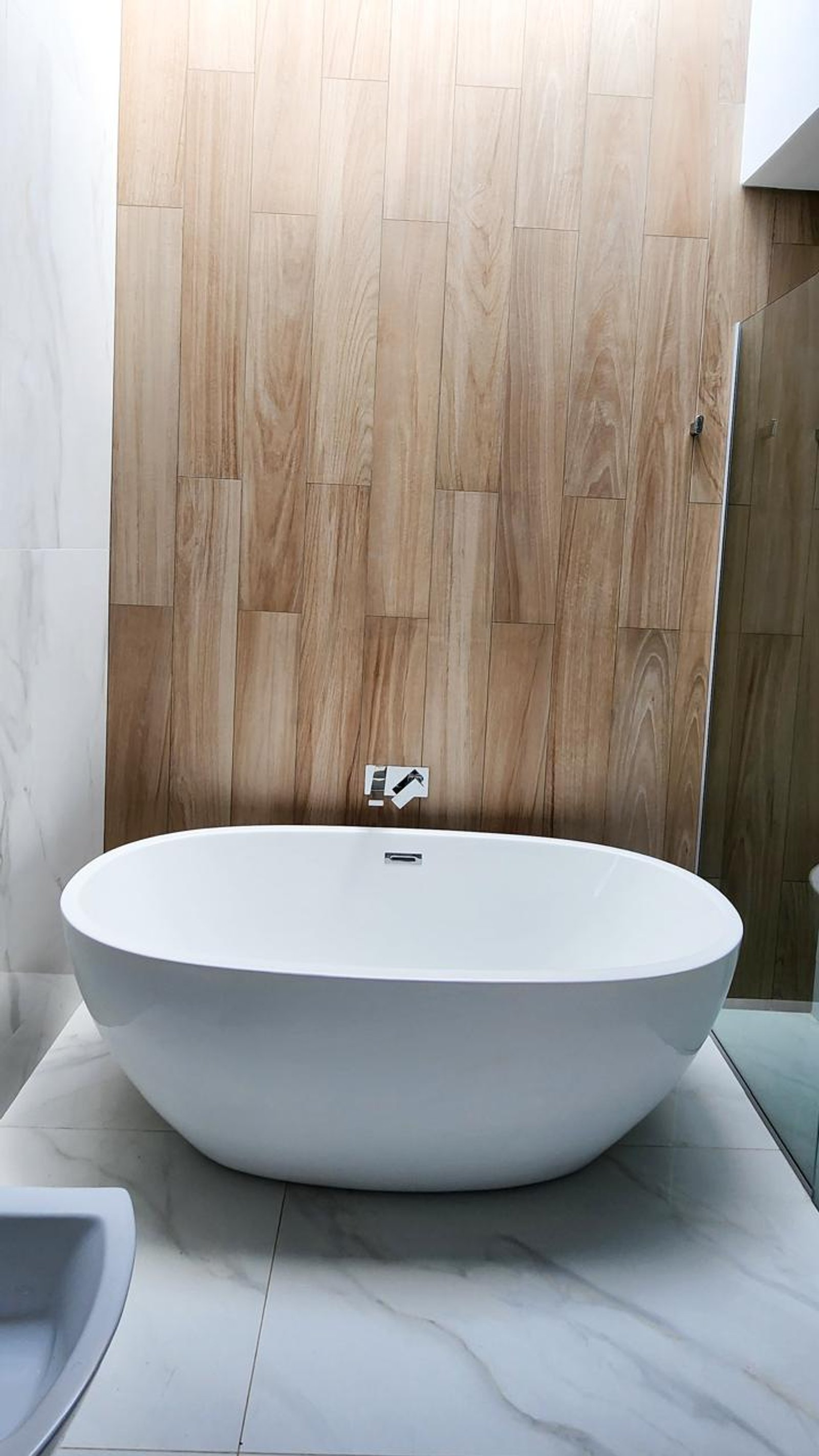 Banheiro moderno com banheira de imersão e parede ripada — projeto Canning, por Eniraestudio, em Canning